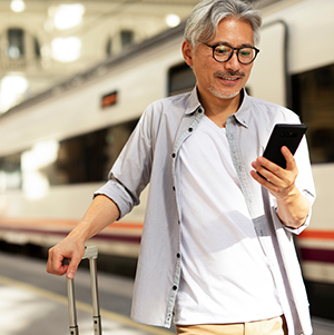 Man using the phone while waiting for train