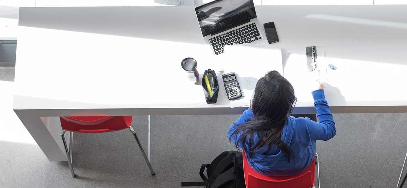 Student studying with laptop and phone