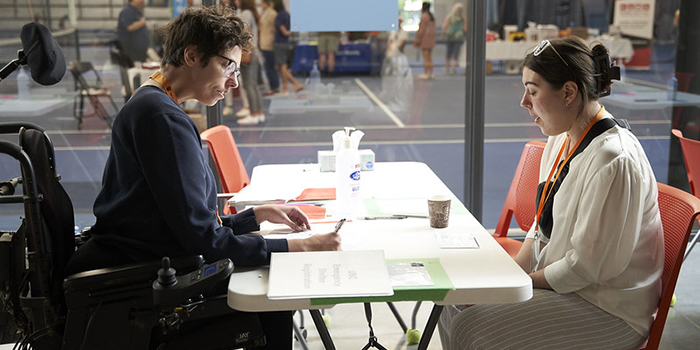 UBC staff member collects information from a person and fills out a form