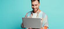 Man smiling holding laptop