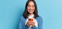 Woman smiling while watching something on her mobile phone