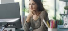 Woman sitting at computer reviewing web content 