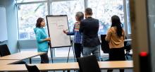 Business team collaborate at a large notepad