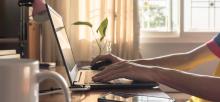 Sitting at desk typing on laptop keyboard